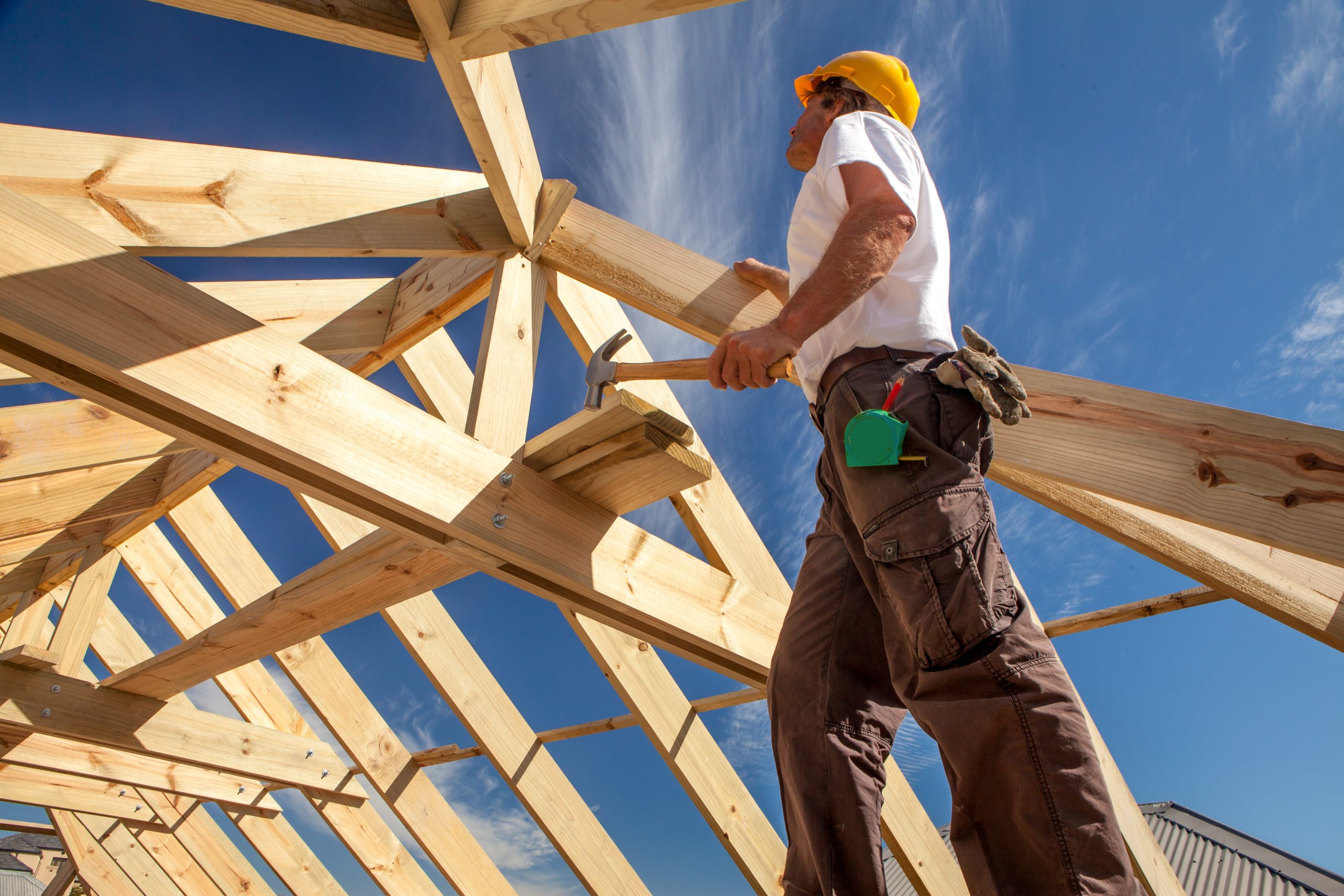 roofer builder working on roog structure of building on construc